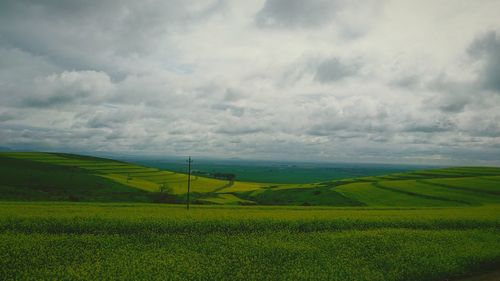 Scenic view of field against cloudy sky