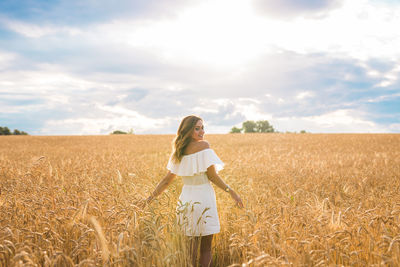 Woman standing on field against sky