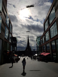 People walking on street amidst buildings in city