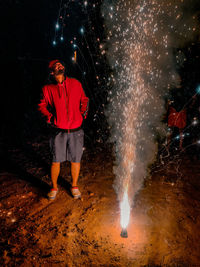 Woman with umbrella standing at night