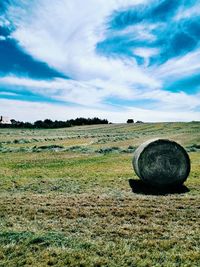 Scenic view of grassy field against cloudy sky