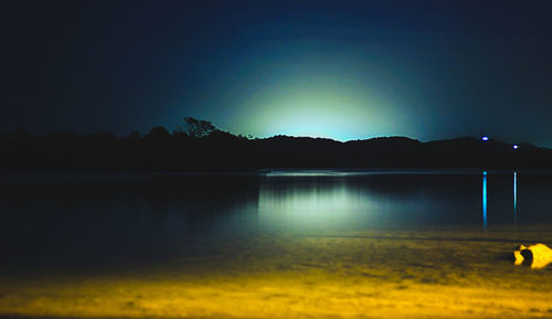 Scenic view of lake against sky at night