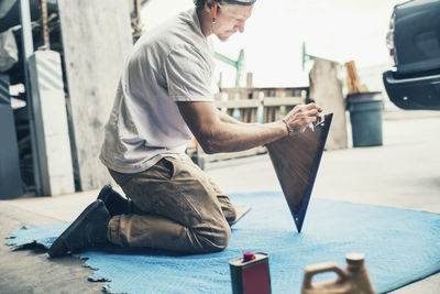 Carpenter polishing triangle shaped wood at workshop