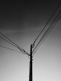Low angle view of power lines against sky