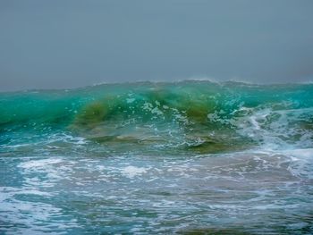 Water splashing in sea against clear sky