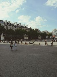 People on street in city against sky