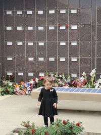 Full length of a woman standing by flowering plants