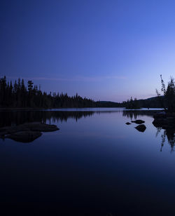 Scenic view of lake against clear sky at sunset