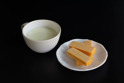 Close-up of tea cup on table against black background