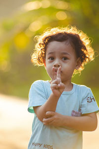 Portrait of cute boy gesturing standing outdoors