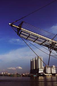 Low angle view of crane against sky