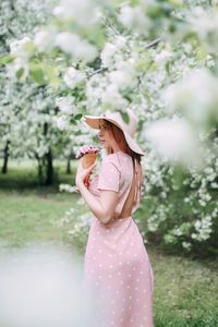 Woman standing on pink flower in field