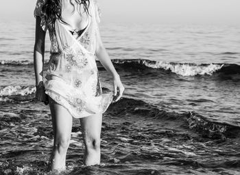 Midsection of woman standing in sea