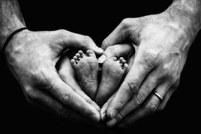 Close-up of parents hands holding baby