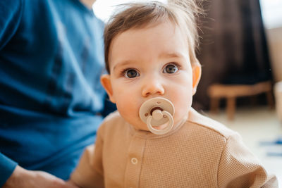 Child with a pacifier in the mouth father in the background selective focus