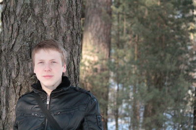 Portrait of young man standing in forest