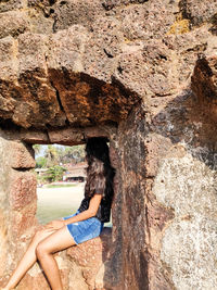 Side view of woman standing on rock