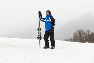 Full length of man standing on snow covered mountain