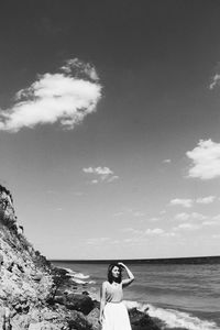 Woman standing on beach against sky