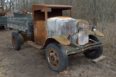 Old abandoned car on field