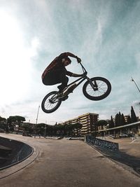 Man riding bicycle on road against sky