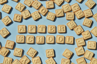 Close-up of biscuits arranged as after school text on table