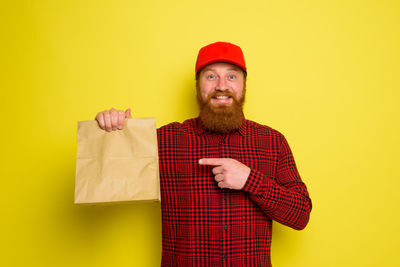 Portrait of a man wearing hat against yellow background