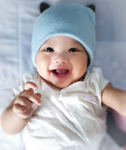 High angle portrait of cute baby girl lying on bed