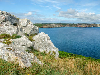 Rock formations by sea against sky