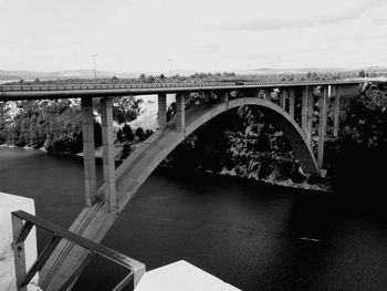 Arch bridge over river against sky