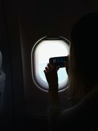 Woman taking picture on airplane