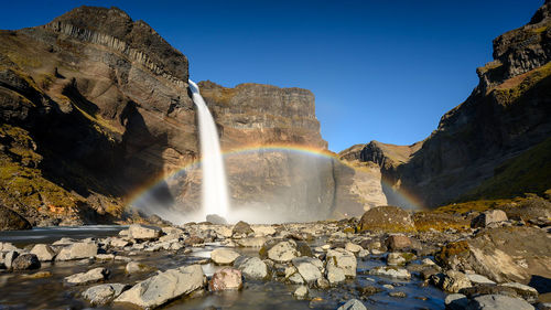 Scenic view of waterfall against sky