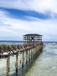 Wooden bridge over sea against the sky