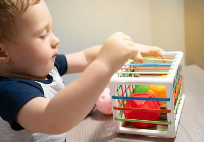 A cute toddler boy is playing a game with sensory colorful balls. sensory and tactile activities.