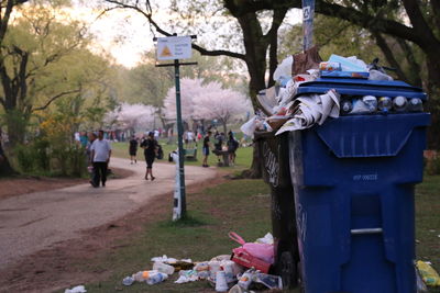 Garbage cans in park against trees