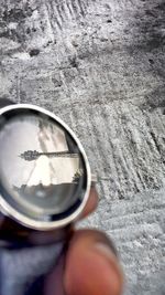 Close-up of hand holding sunglasses with reflection