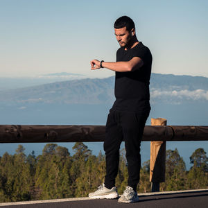 Full length of man standing on mountain against sky