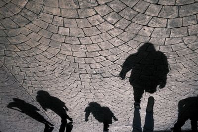 Shadow of people walking on footpath