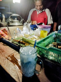 Midsection of man with drink on table in restaurant