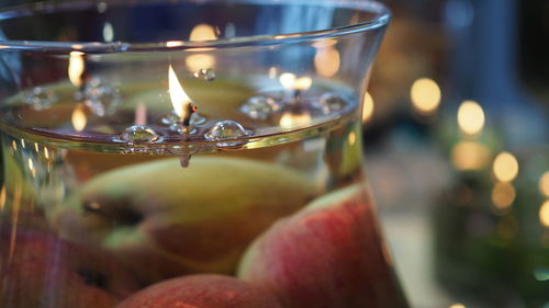 Close-up of burning matchstick in jar with water on table