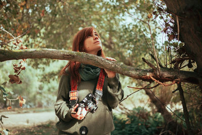 Young woman looking away in forest