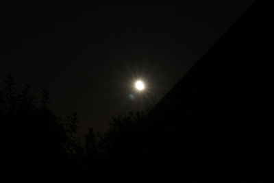 Low angle view of silhouette trees against clear sky at night