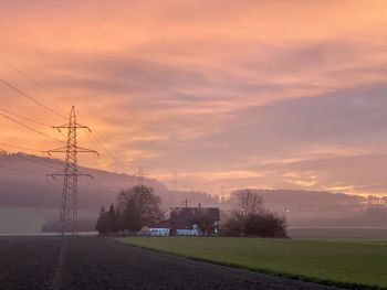 Electricity pylon on field against sky during sunset