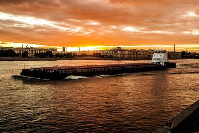 Boats moored at harbor against sky during sunset