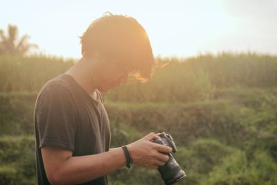 Young man using camera on field
