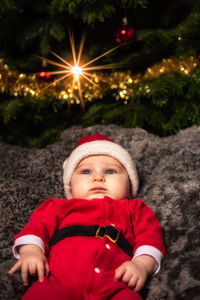 Cute baby boy wearing santa costume during christmas