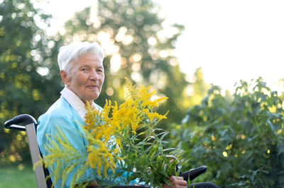Portrait of smiling woman holding plant