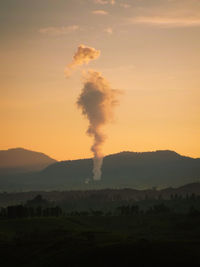 Smoke emitting from chimney against sky during sunset