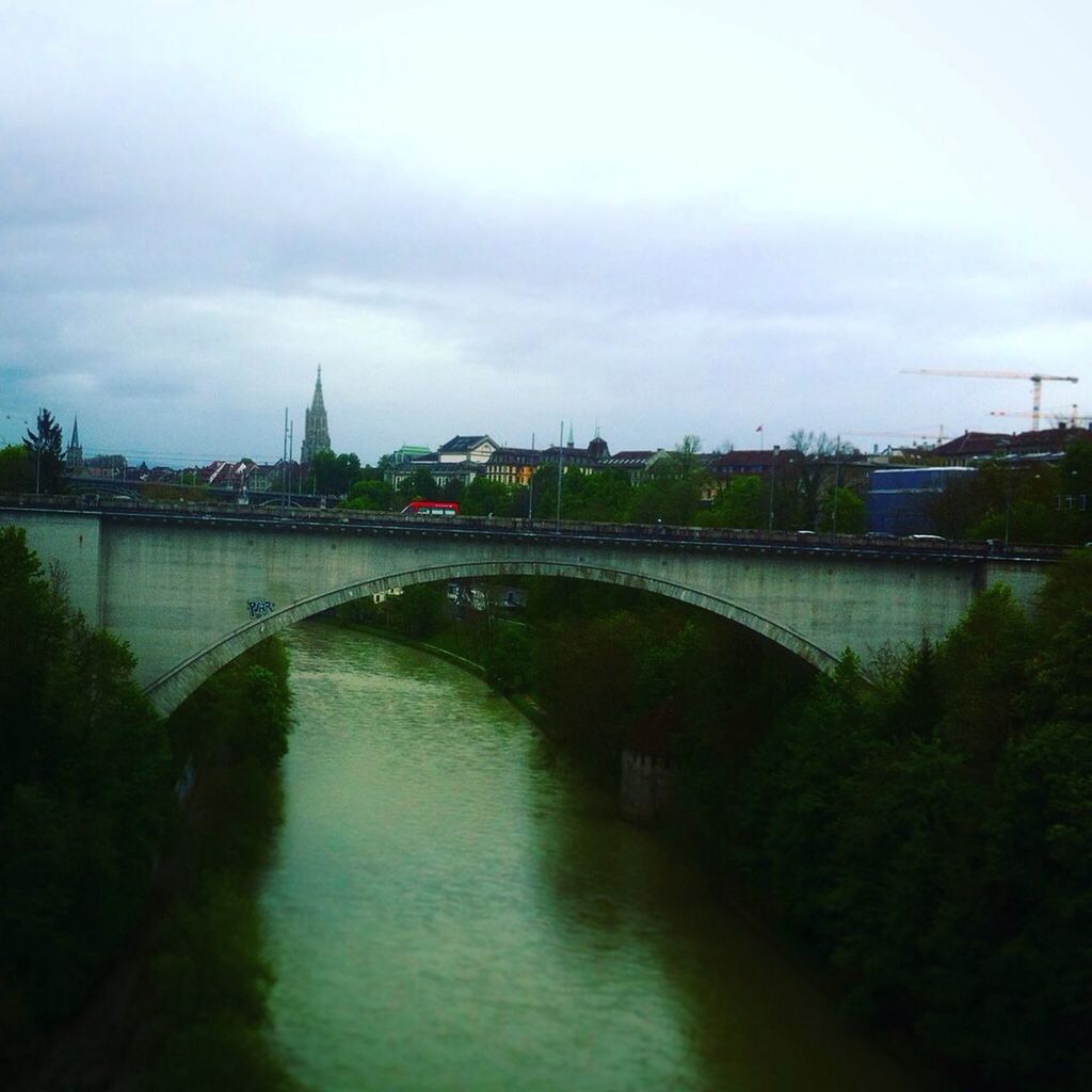 bridge - man made structure, connection, architecture, river, built structure, water, sky, city, outdoors, no people, day, transportation, bridge, building exterior, travel destinations, cloud - sky, cityscape, tree, nature, chain bridge