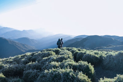 People on mountain against sky